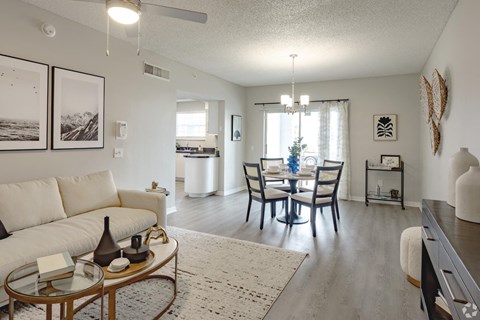 a living room and dining room with a table and chairs